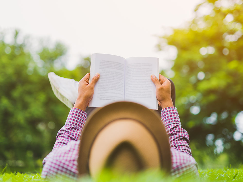 Man reading book outside.